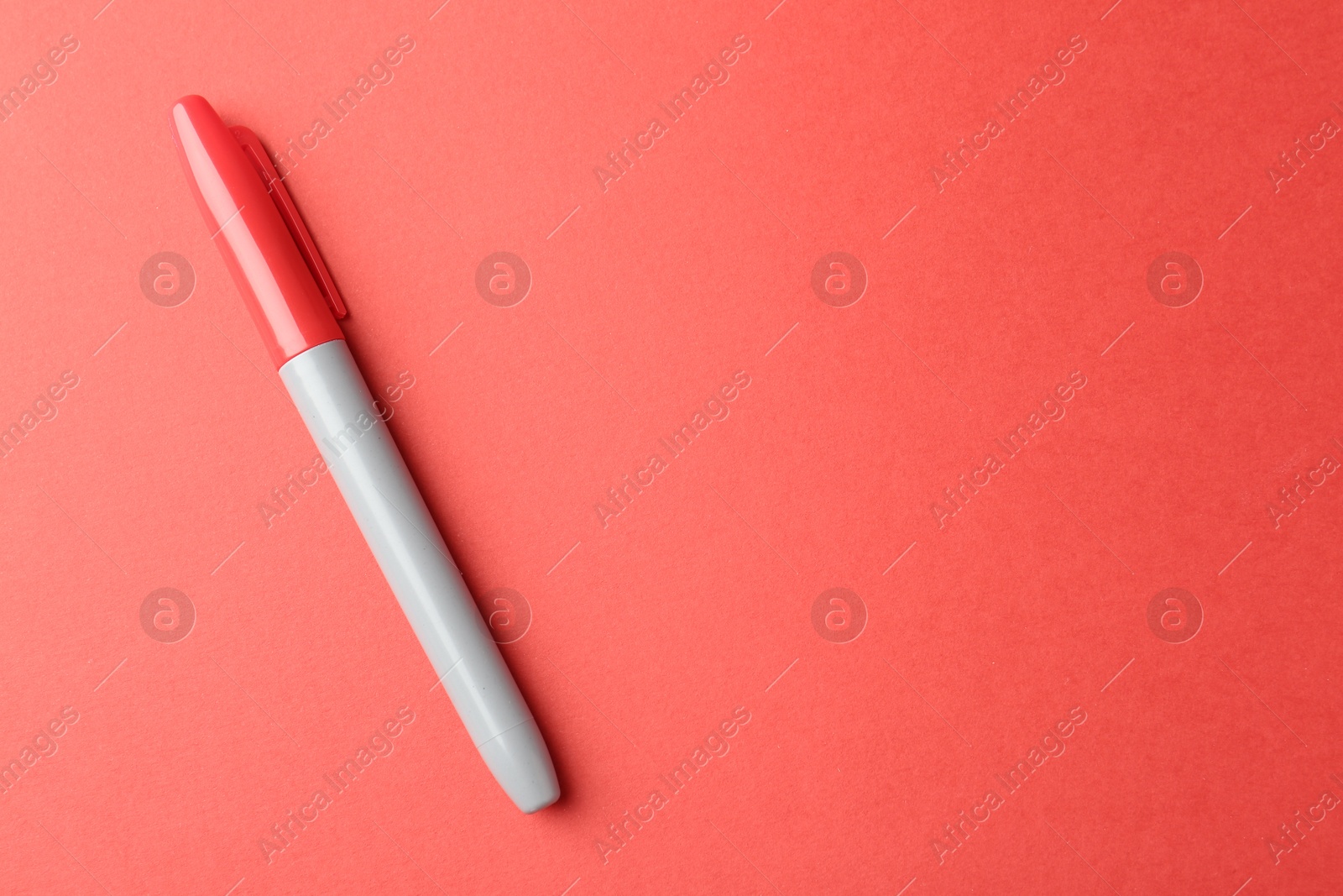 One color marker on red background, top view. Space for text Photo of One color marker on red background, top view. Space for text