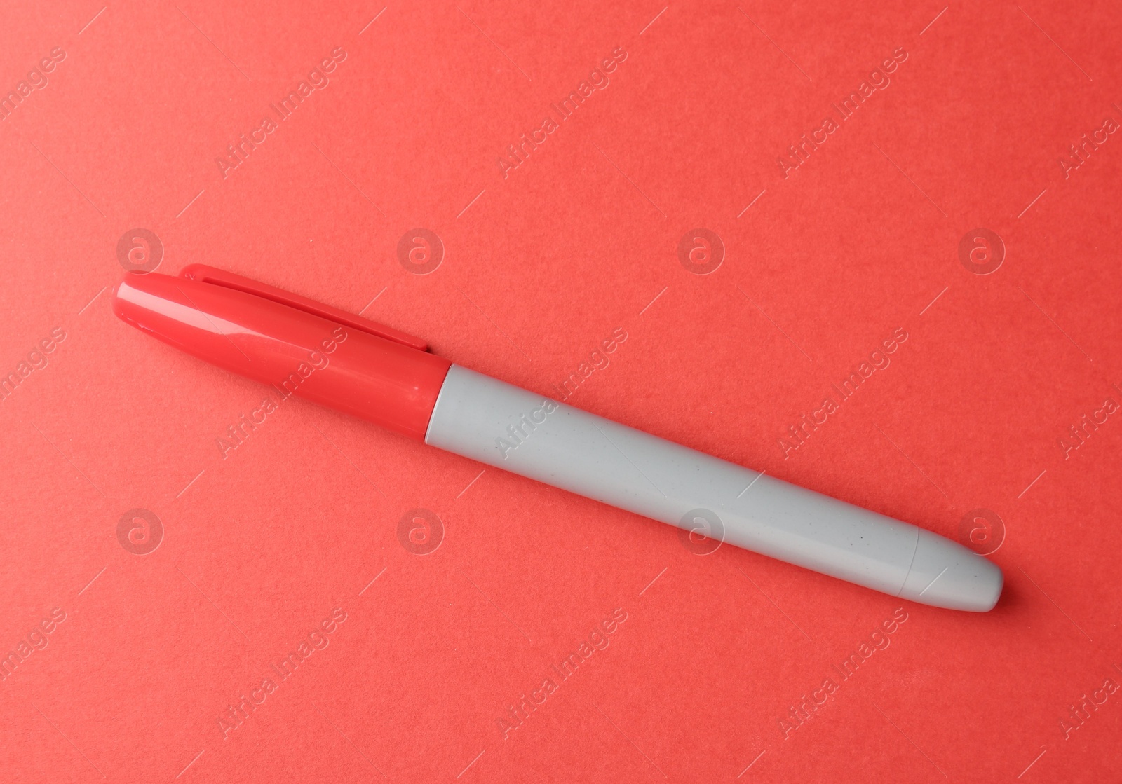 One color marker on red background, top view. Space for text Photo of One color marker on red background, top view. Space for text