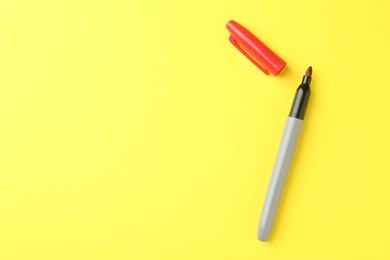 Photo of One red marker on yellow background, top view. Space for text