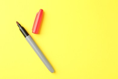 Photo of One red marker on yellow background, top view. Space for text