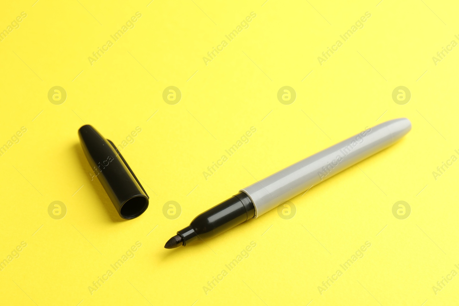 One black marker on yellow background. Space for text Photo of One black marker on yellow background. Space for text