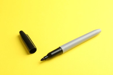 Photo of One black marker on yellow background. Space for text