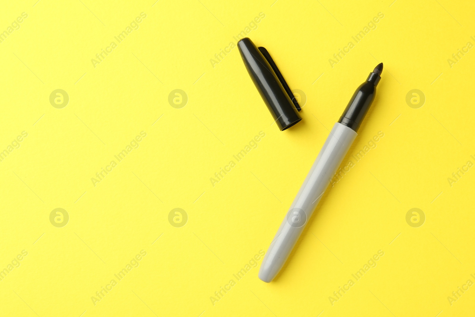 One black marker on yellow background, top view. Space for text Photo of One black marker on yellow background, top view. Space for text