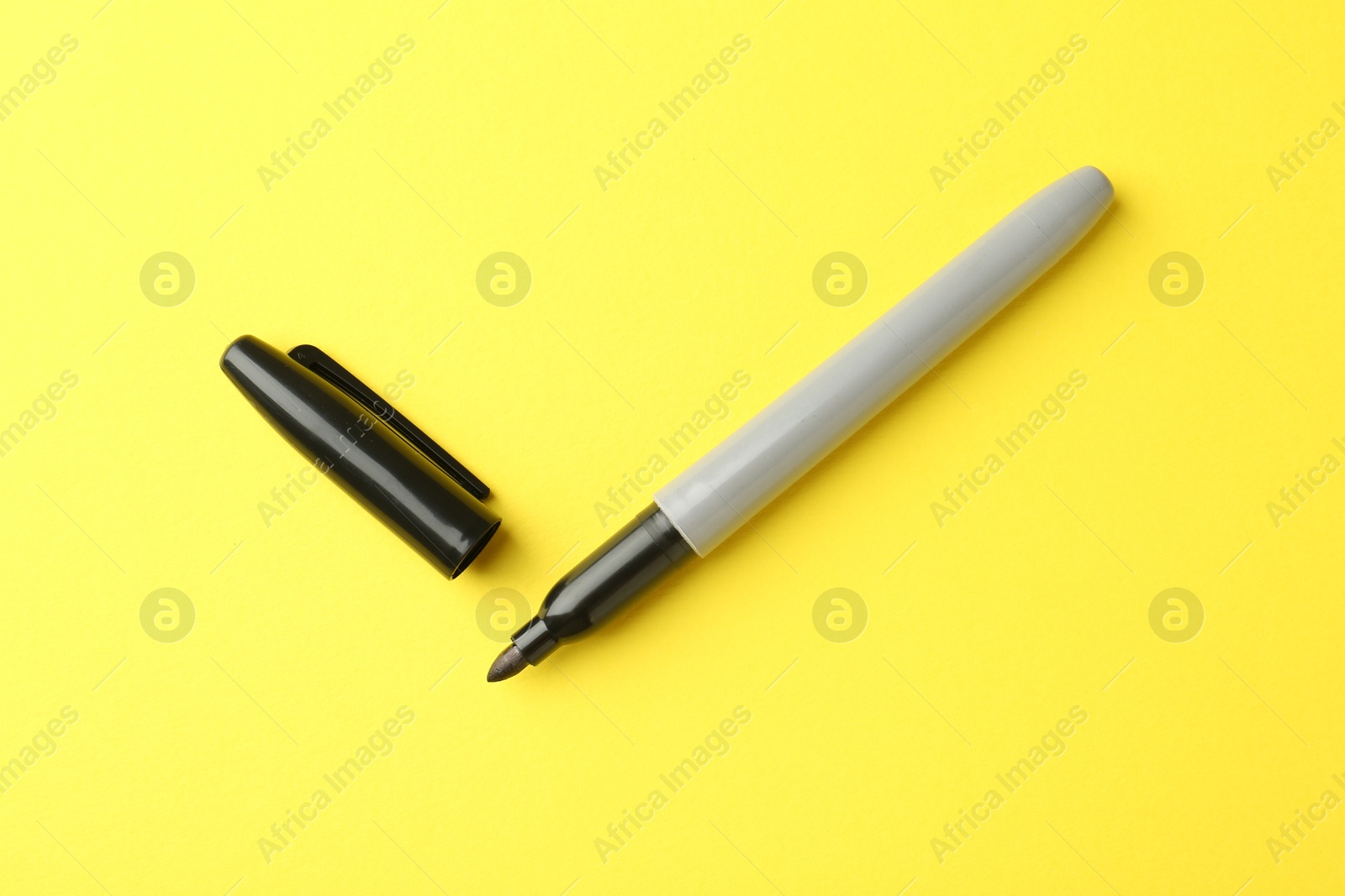 One black marker on yellow background, top view Photo of One black marker on yellow background, top view