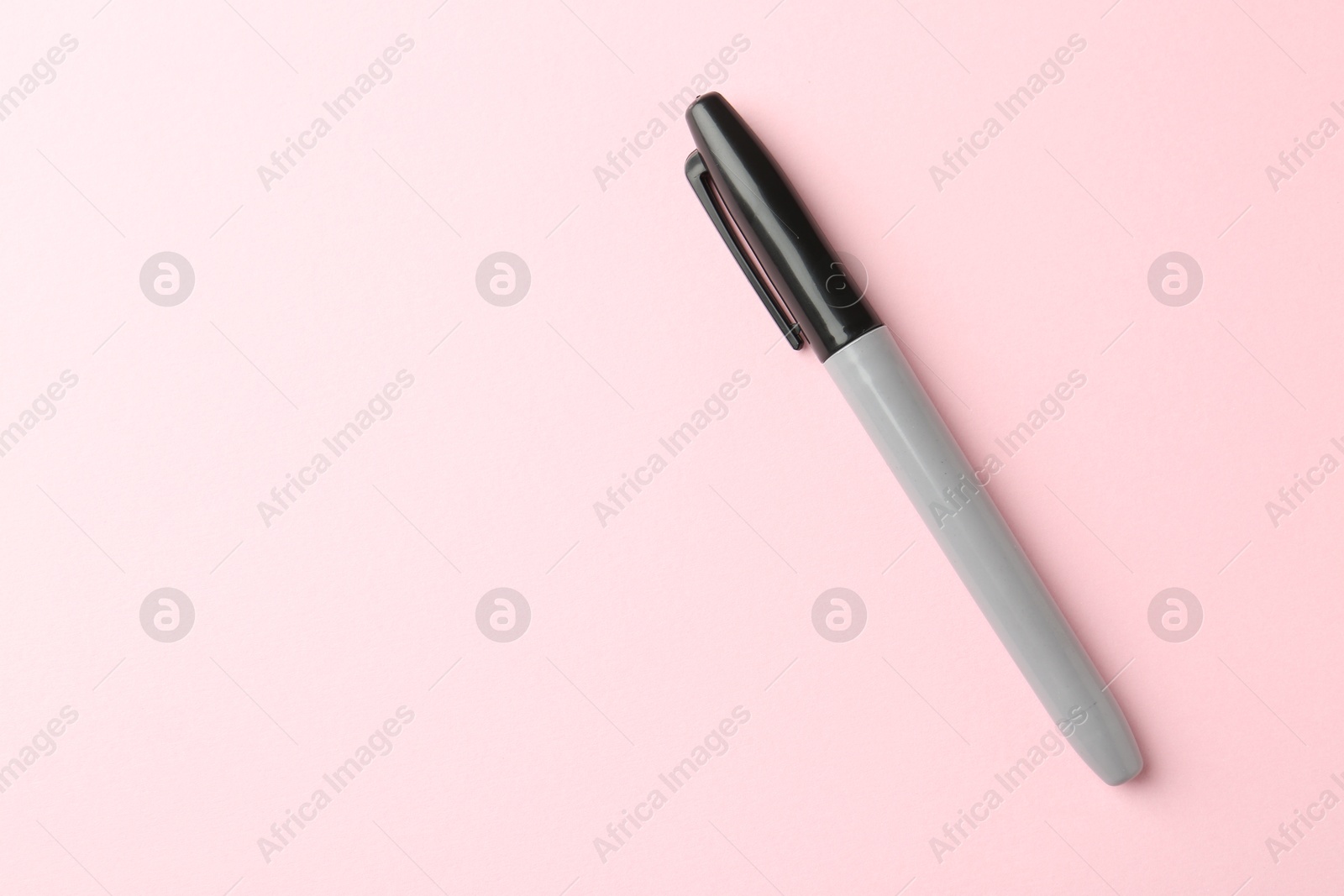 One black marker on light pink background, top view. Space for text Photo of One black marker on light pink background, top view. Space for text