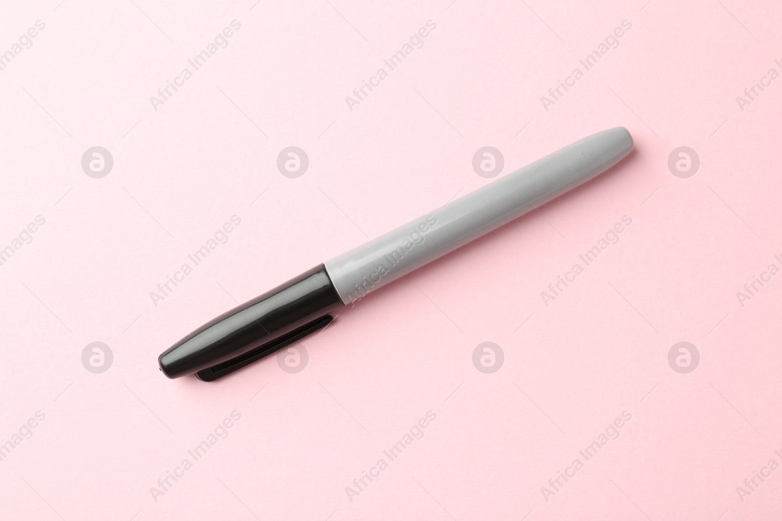 One black marker on light pink background, top view Photo of One black marker on light pink background, top view