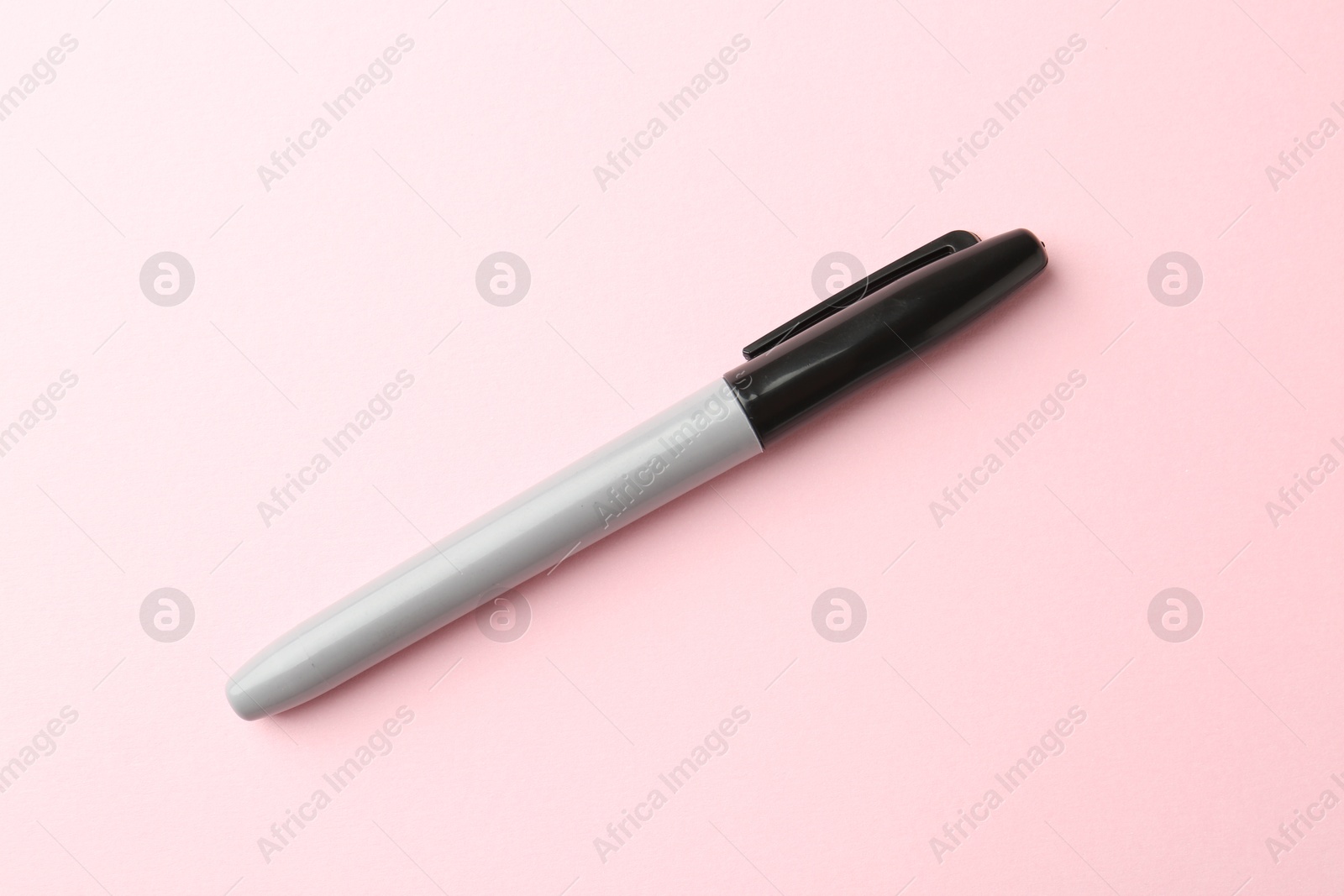 One black marker on light pink background, top view Photo of One black marker on light pink background, top view