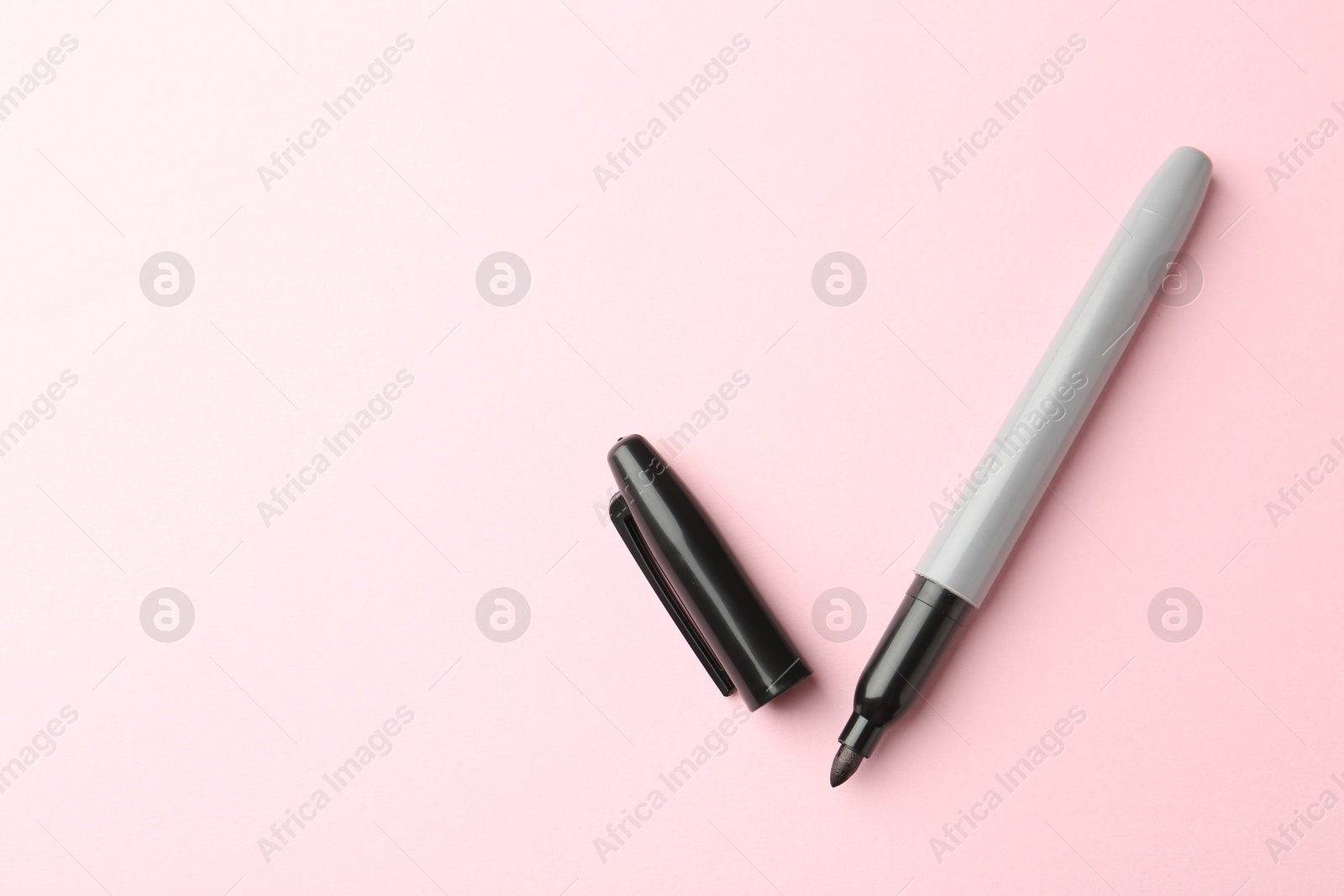 One black marker on light pink background, top view. Space for text Photo of One black marker on light pink background, top view. Space for text