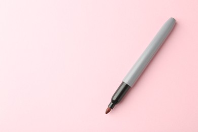 Photo of One red marker on light pink background, top view. Space for text