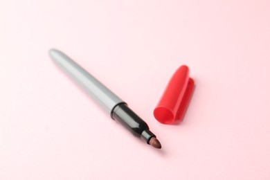 Photo of One red marker on light pink background
