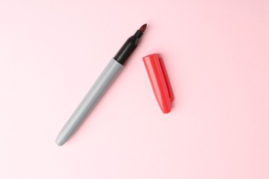 Photo of One red marker on light pink background, top view