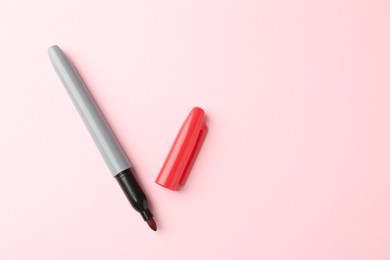 Photo of One red marker on light pink background, top view. Space for text