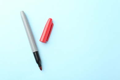 Photo of One red marker on light blue background, top view. Space for text