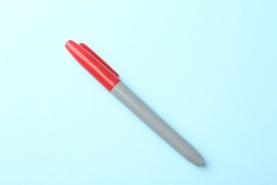 Photo of One red marker on light blue background, top view