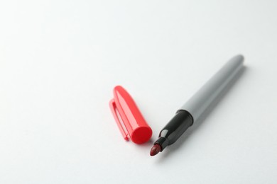 Photo of One red marker on light background, closeup. Space for text