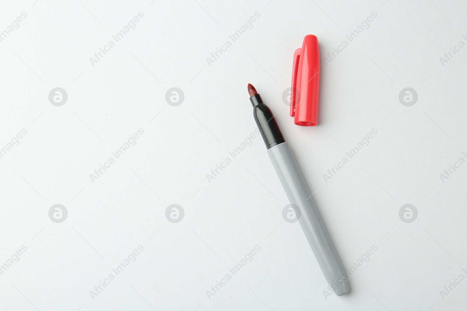 One red marker on light background, top view. Space for text Photo of One red marker on light background, top view. Space for text