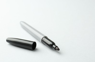 Photo of One black marker on light background. Space for text
