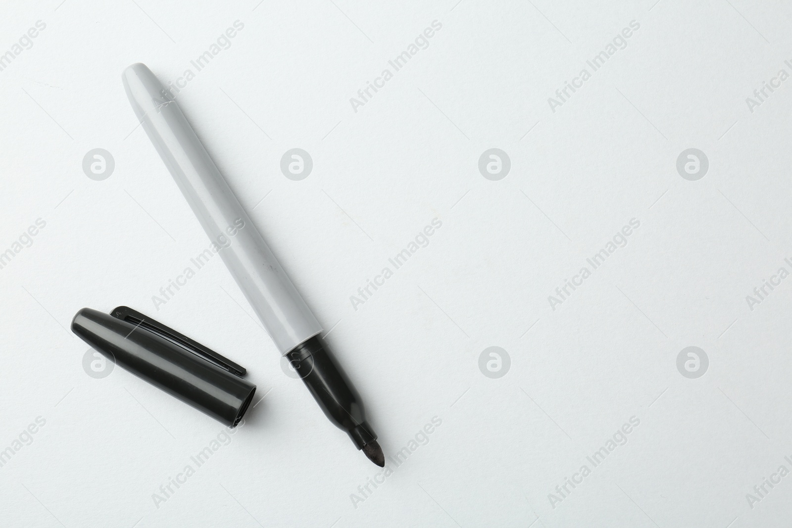 One black marker on light background, top view. Space for text Photo of One black marker on light background, top view. Space for text