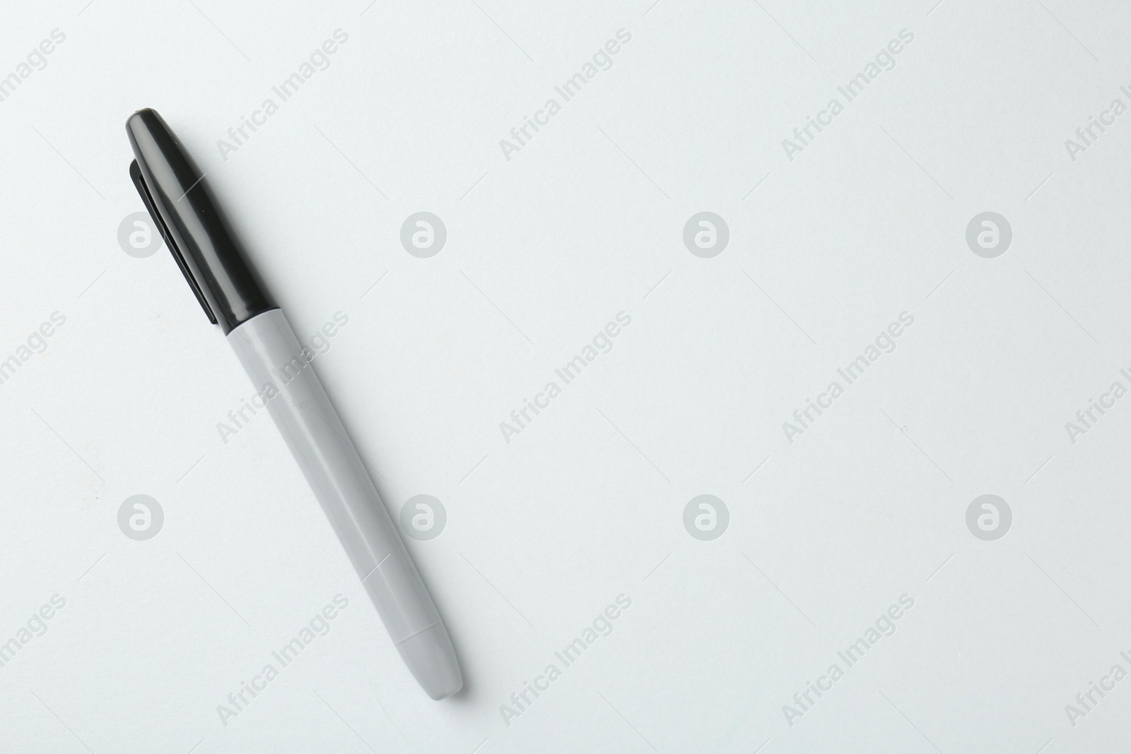 One black marker on light background, top view. Space for text Photo of One black marker on light background, top view. Space for text