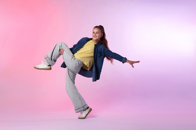 Photo of Girl in stylish clothes dancing on color background