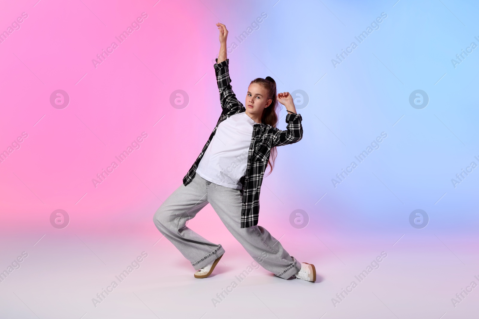 Photo of Girl in stylish clothes dancing on color background
