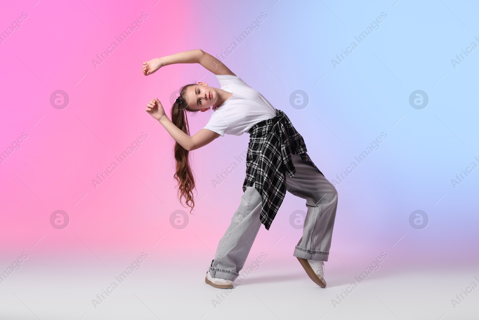 Photo of Girl in stylish clothes dancing on color background