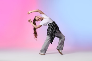 Photo of Girl in stylish clothes dancing on color background