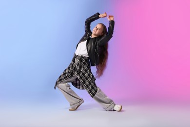 Photo of Girl in stylish clothes dancing on color background