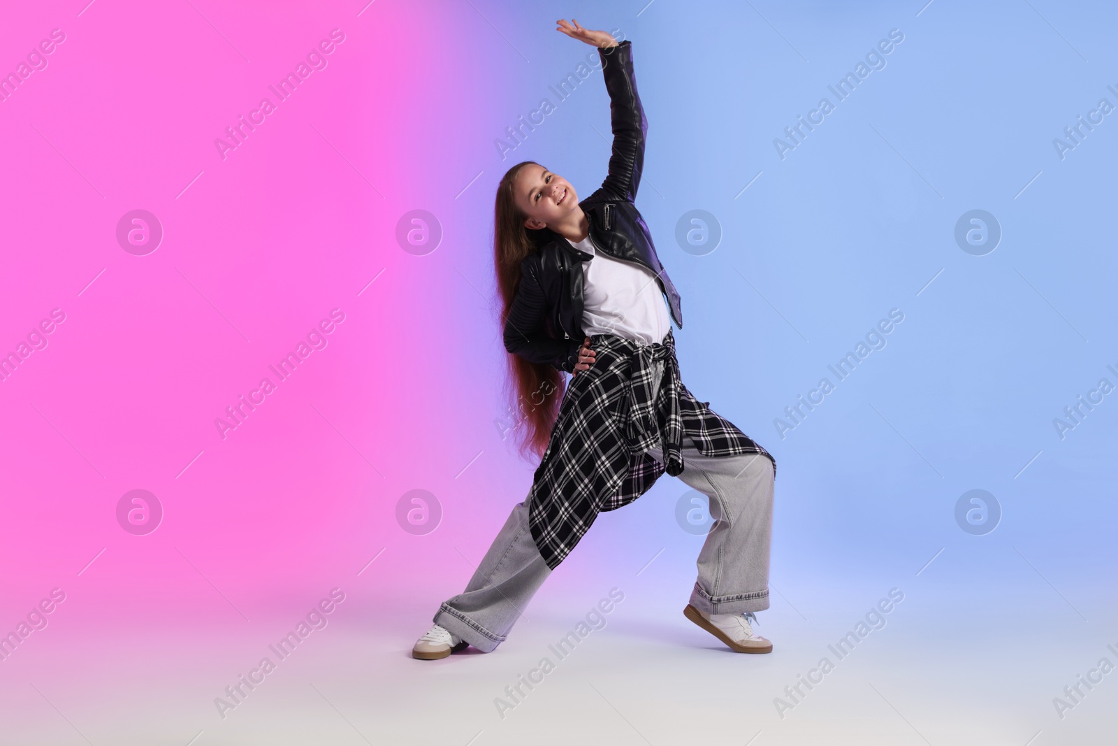 Photo of Girl in stylish clothes dancing on color background