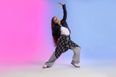 Photo of Girl in stylish clothes dancing on color background