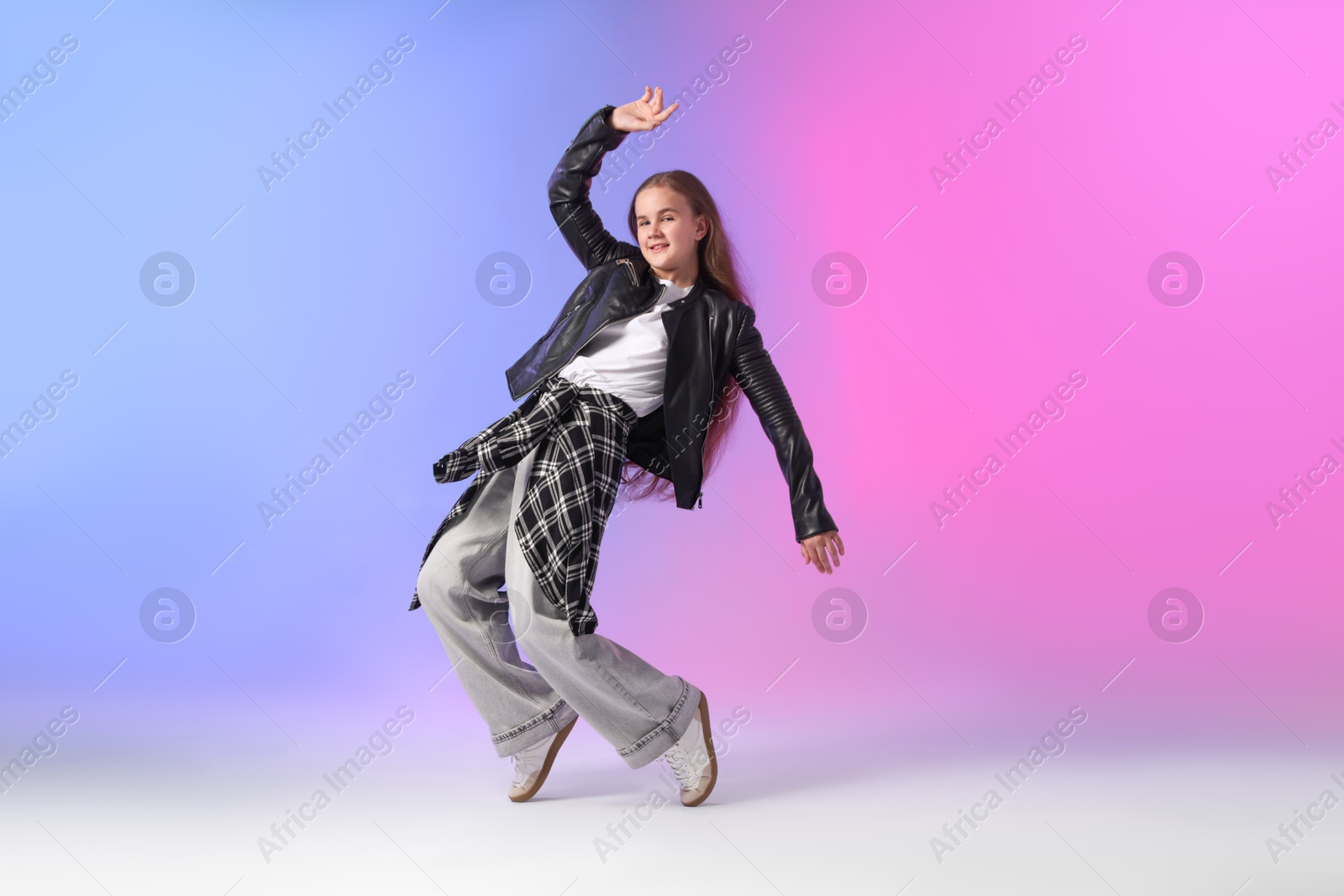 Photo of Girl in stylish clothes dancing on color background