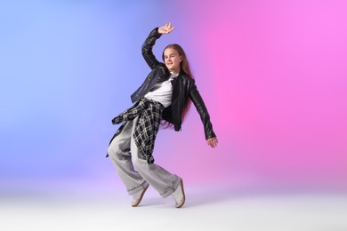 Photo of Girl in stylish clothes dancing on color background