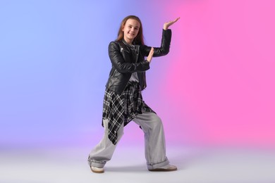 Photo of Girl in stylish clothes dancing on color background