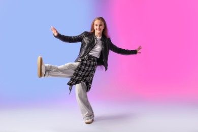 Photo of Girl in stylish clothes dancing on color background