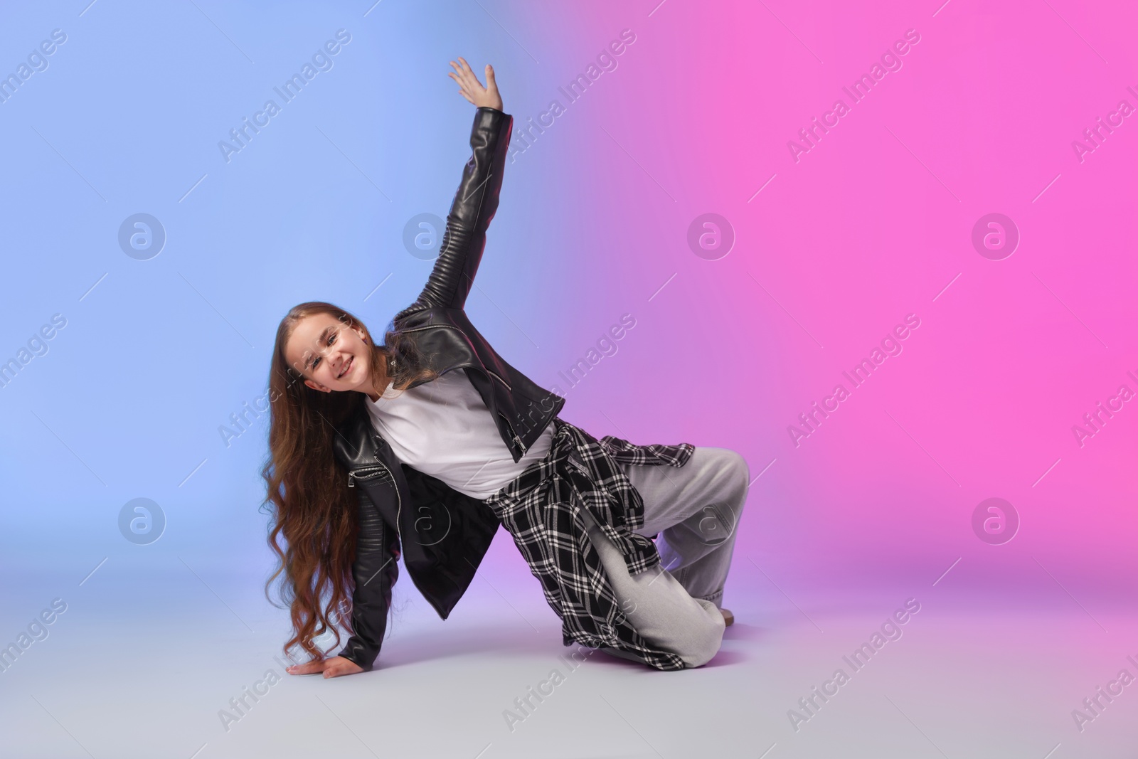 Photo of Girl in stylish clothes dancing on color background