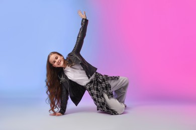 Photo of Girl in stylish clothes dancing on color background