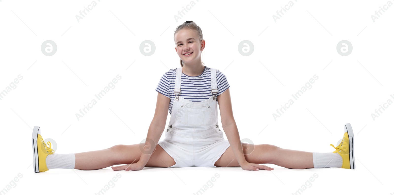 Photo of Girl in stylish clothes practicing split on white background. Dance