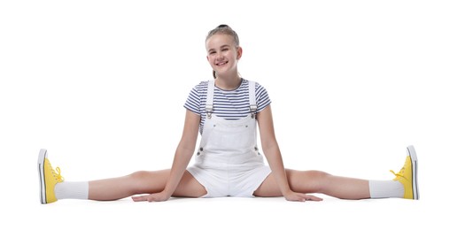 Photo of Girl in stylish clothes practicing split on white background. Dance