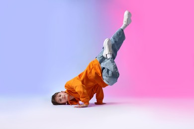 Photo of Boy in stylish clothes dancing on color background