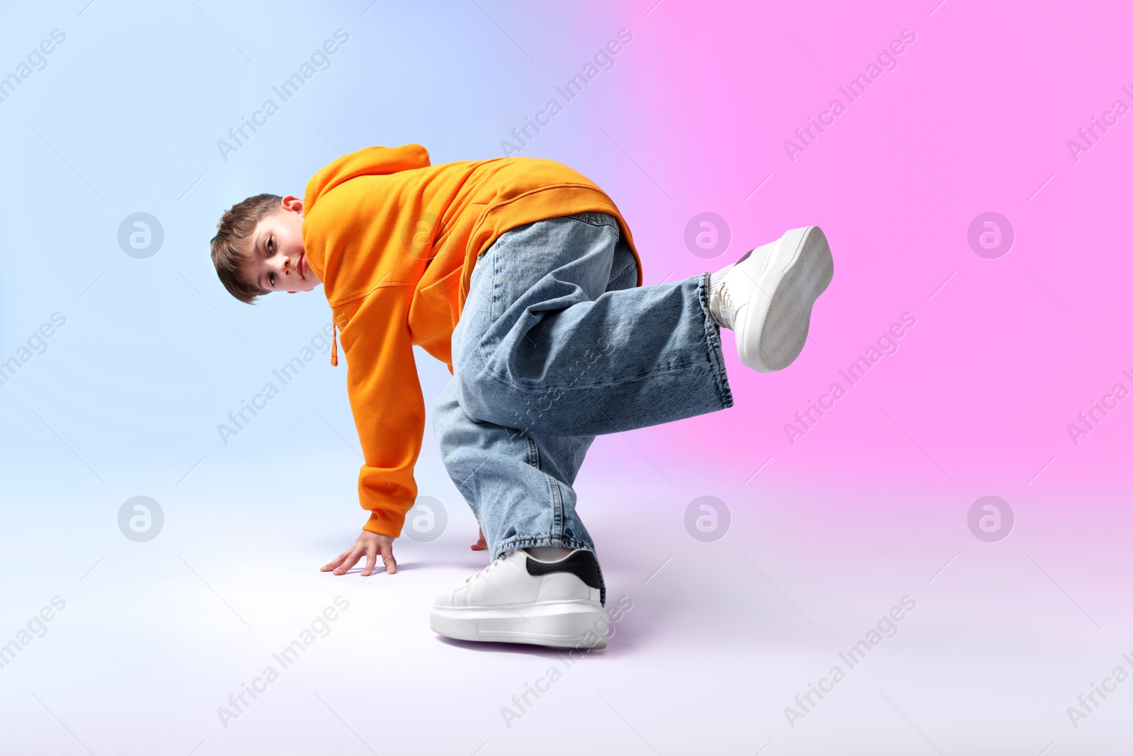 Photo of Boy in stylish clothes dancing on color background