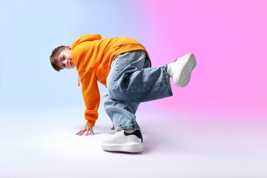 Photo of Boy in stylish clothes dancing on color background