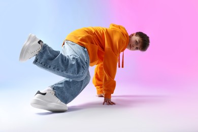 Photo of Boy in stylish clothes dancing on color background