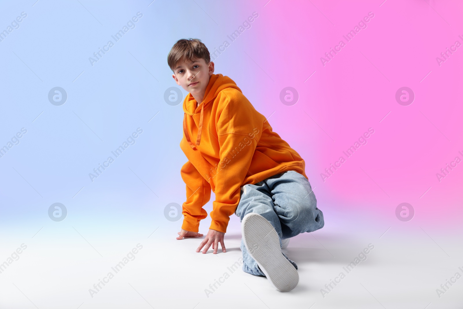 Boy in stylish clothes dancing on color background Photo of Boy in stylish clothes dancing on color background