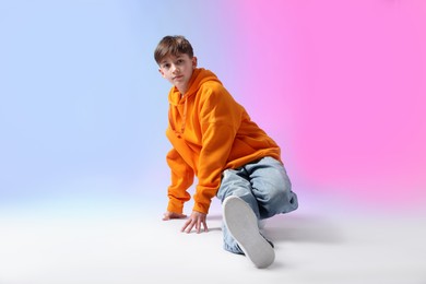Photo of Boy in stylish clothes dancing on color background