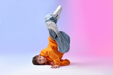 Photo of Boy in stylish clothes dancing on color background