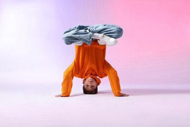 Photo of Boy in stylish clothes dancing on color background