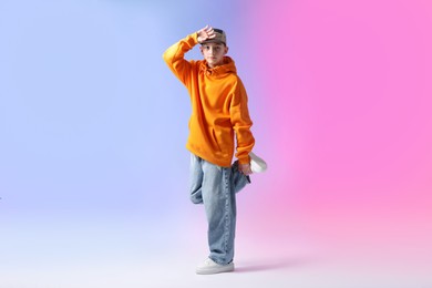 Photo of Boy in stylish clothes dancing on color background