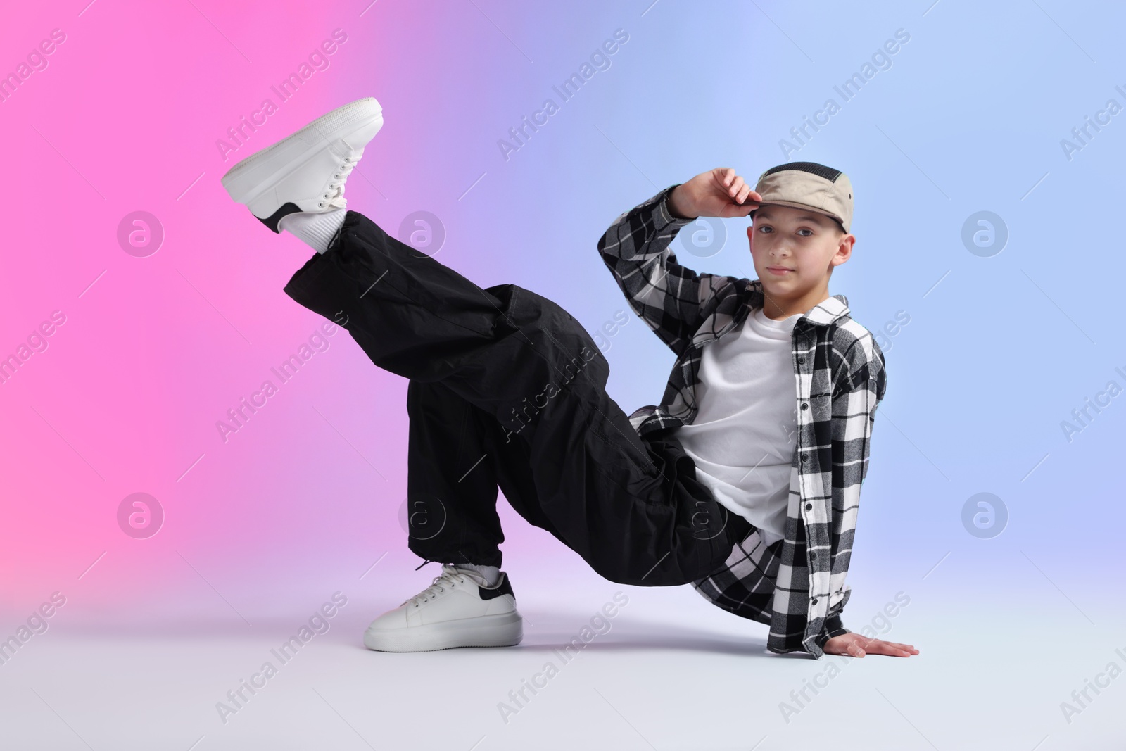 Photo of Boy in stylish clothes dancing on color background