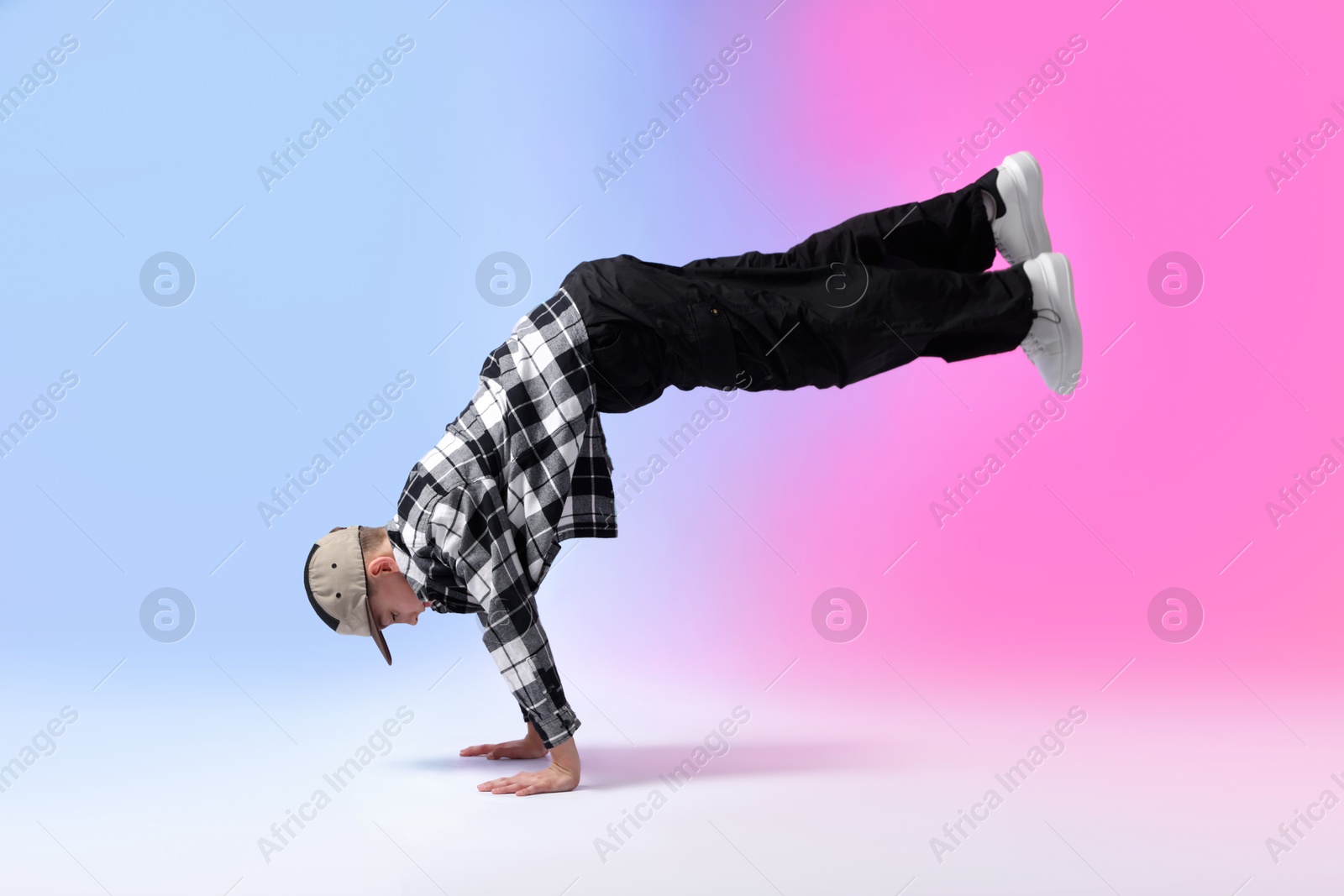 Photo of Boy in stylish clothes dancing on color background