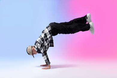 Photo of Boy in stylish clothes dancing on color background